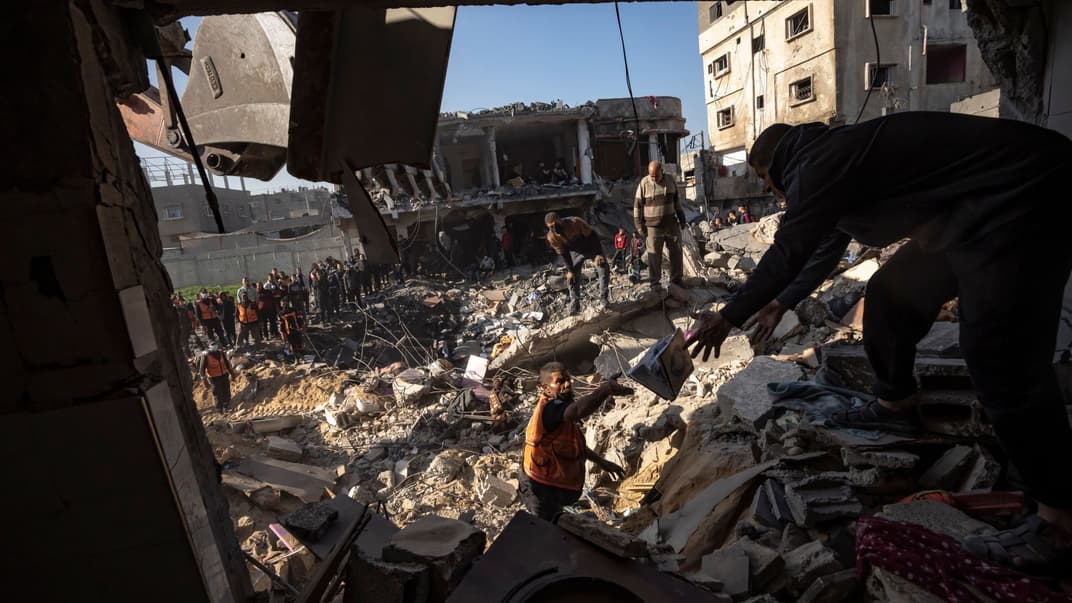 Палестинцы ищут погибших и выживших среди обломков жилого дома, разрушенного израильским авиаударом, в городе Рафах на юге Сектора Газа, 19 декабря 2023 года