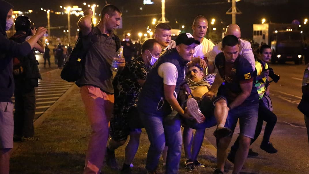 Протестующие несут раненого товарища в карету скорой помощи в Минске, 9 августа 2020 года