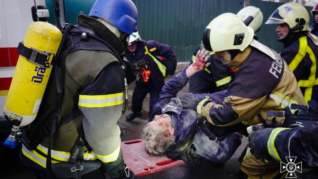 Спасатели эвакуируют человека после российских обстрелов по Киеву, 29 декабря 2023 года
