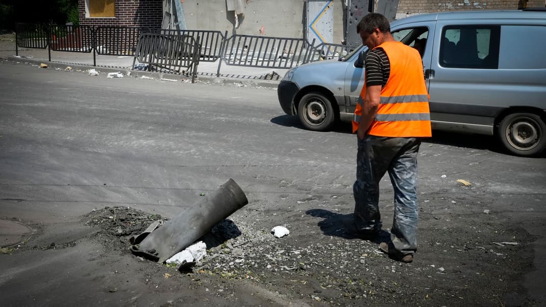 Комунальний працівник проходить повз уламок російської ракети після нічного обстрілу міста Бахмут Донецької області, 13 червня 2022 року