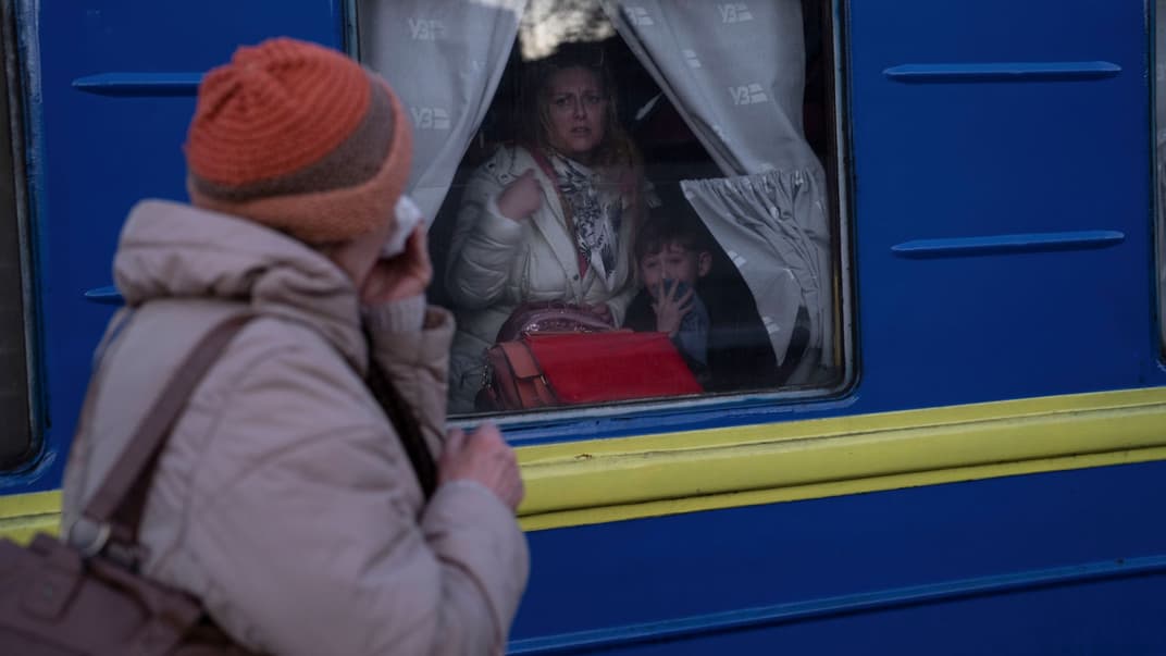  Жінка прощається з онукою, яка разом із сином виїжджає з вокзалу в Одесі, 22 березня 2022 року