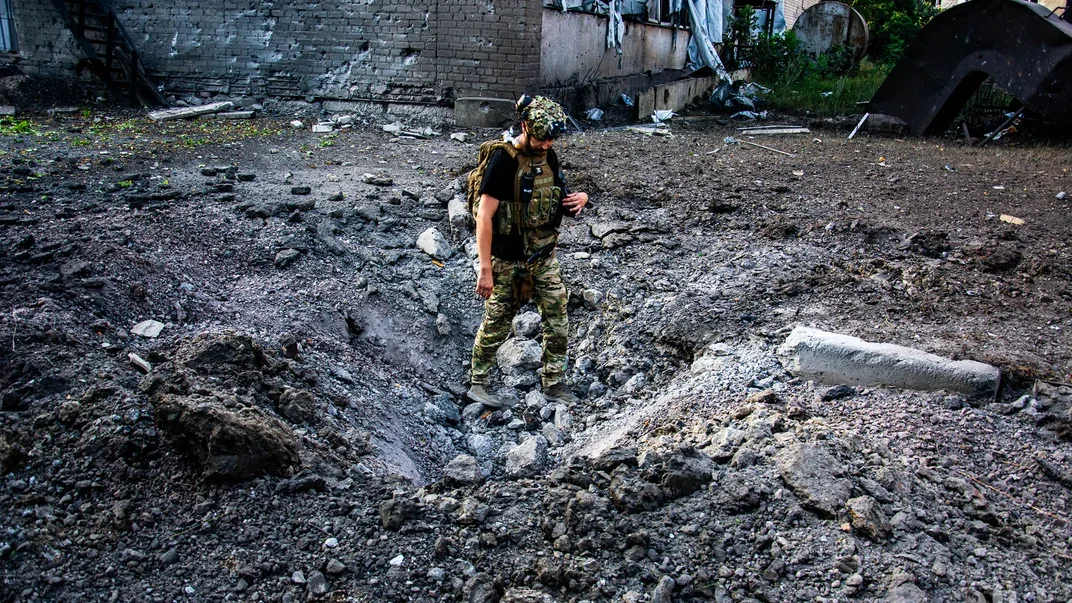 Украинский военный в воронке от разорванного снаряда