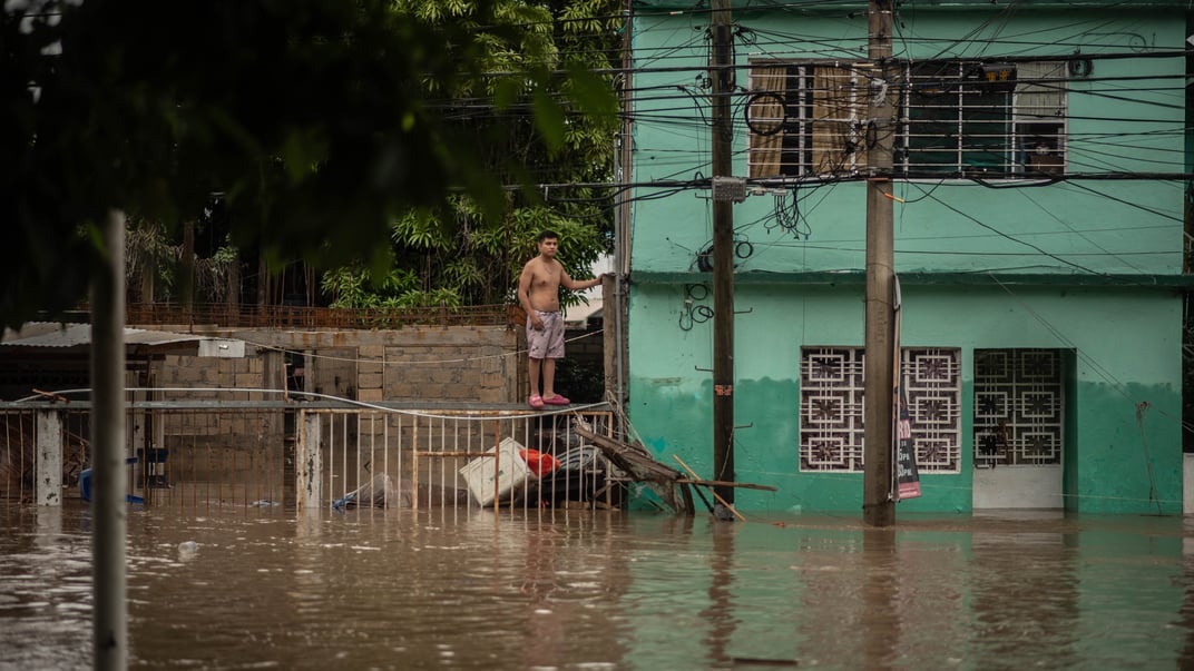 Чоловік спостерігає за своєю затопленою вулицею після проливних дощів, що пройшли в Поса-Ріці, Мексика, 10 жовтня 2025 року