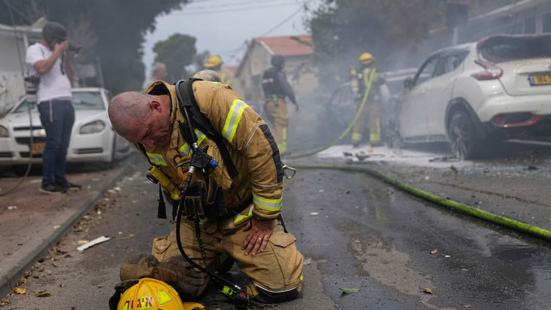 Израильский пожарный после того, как он и его коллеги в городе Ашкелони тушили автомобили, подожженные ракетой, выпущенной из Cектора Газа, 9 октября 2023 года.