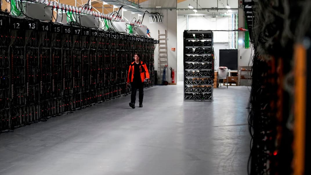 Працівник проходить уздовж ряду комп'ютерних установок, які цілодобово видобувають біткойни всередині криптовалютної шахти Genesis Mining у Кефлавіку, Ісландія. 17 січня 2018 року