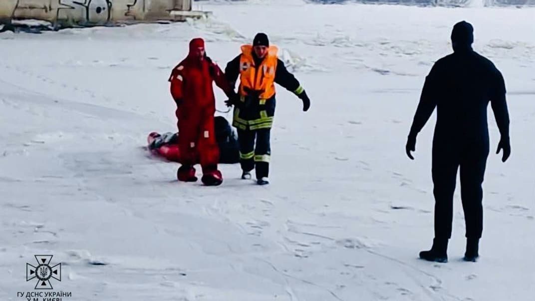 Спасатели помогают мужчине, провалившемуся под лед в Киеве, 14 января 2024 года