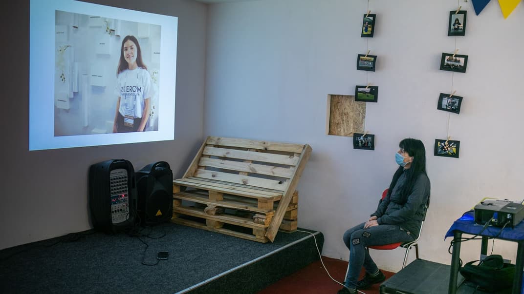 Мама Інни Волкової дивиться на слайд-шоу із фото доньки під час заходу, присвяченого пам'яті дівчини, яка померла 20 жовтня від наслідків коронавірусної інфекції, Київ, 23 жовтня 2020 року.