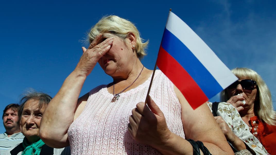 Жінка з російським прапором плаче під час параду в місті Луганськ, східна Україна, 14 вересня 2014 року