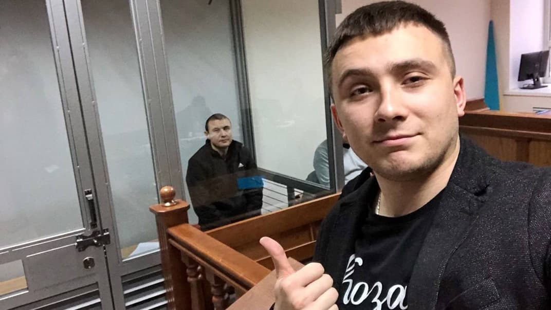Сергій Стерненко позує у залі суду, де на нього дивиться його нападник — Абзал Баймукашев