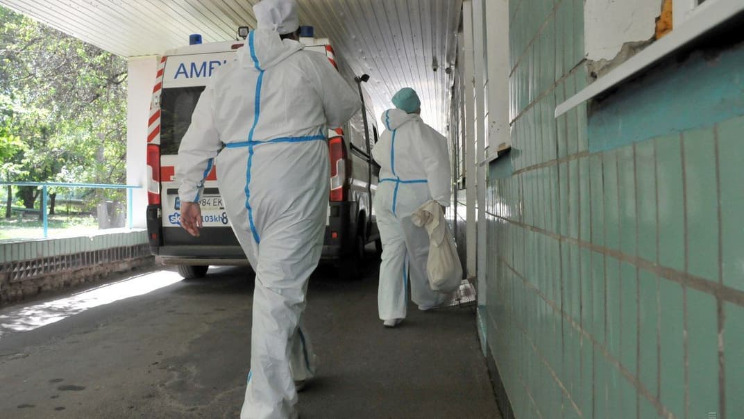 Лікарі в захисних костюмах на території приймального відділення інфекційної лікарні, 16 червня 2020 року