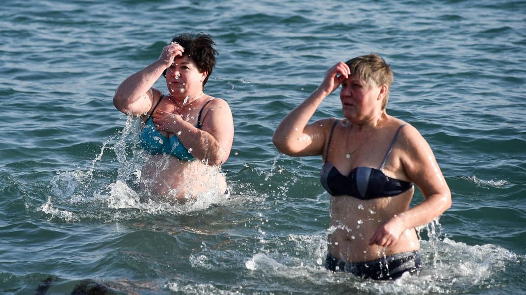 Дві жінки хрестяться під час купання в Чорному морі під час традиційного святкування Водохреща у Севастополі. Під час російського варіанту локдауну, який перетворився на додаткові вихідні з 30 жовтня до 7 листопада росіяни масово рушили до моря.