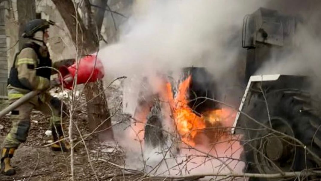 Спасатель тушит поврежденную технику после российского обстрела в Херсонской области, 22 января 2025 года