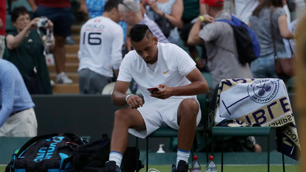 Иллюстративная фотография. Ник Кириос из Австралии смотрит в телефон после поражения в мужском одиночном матче на Уимблдонском теннисном чемпионате в Лондоне, 7 июля 2018 года