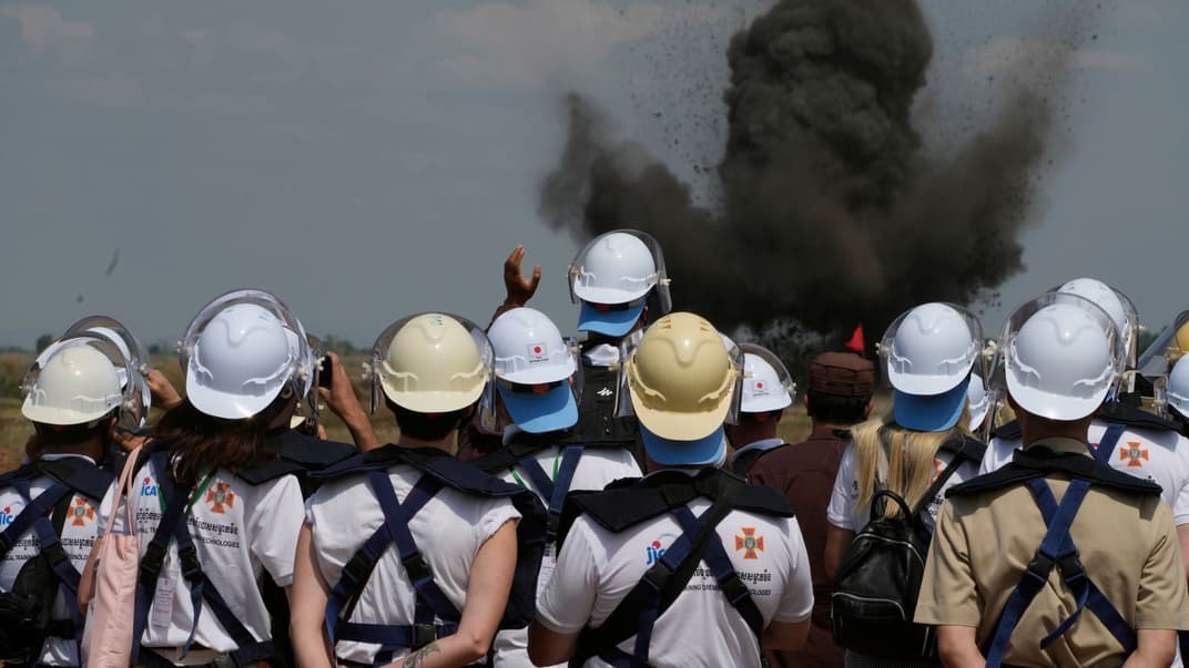 Украинские саперы наблюдают за контролируемым взрывом бомбы на минном поле в селе Прейтотуунг в Камбодже, 19 января 2023 года