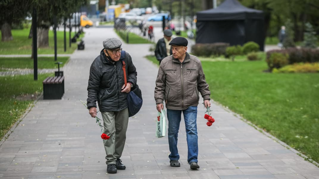 Чоловіки несуть квіти до пам'ятника жертвам розстрілів у Бабиному Яру, 29 вересня 2021 року.