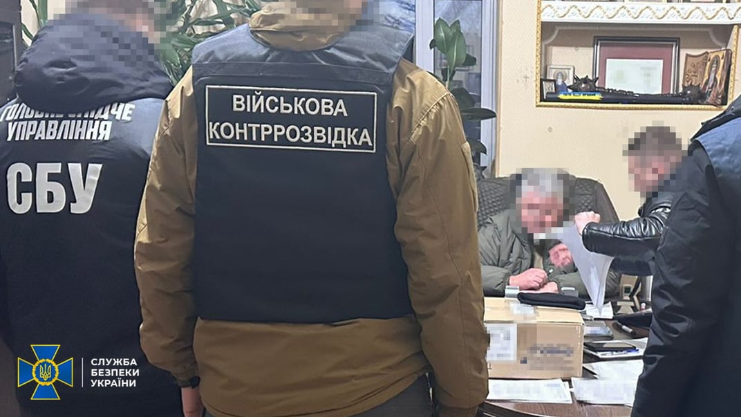 Головний психіатр ЗСУ Олег Друзь (сидить за столом) під час затримання