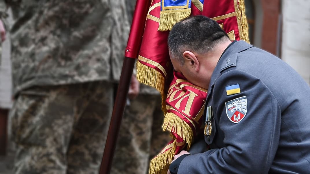 Олександр Трепак цілує бойовий прапор 3 ОП СпП імені князя Святослава Хороброго