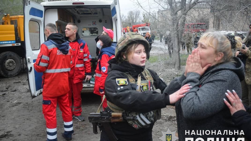 Поліцейська заспокоює жінку в Слов’янську на місці ракетного удару росії, 14 квітня 2023 року