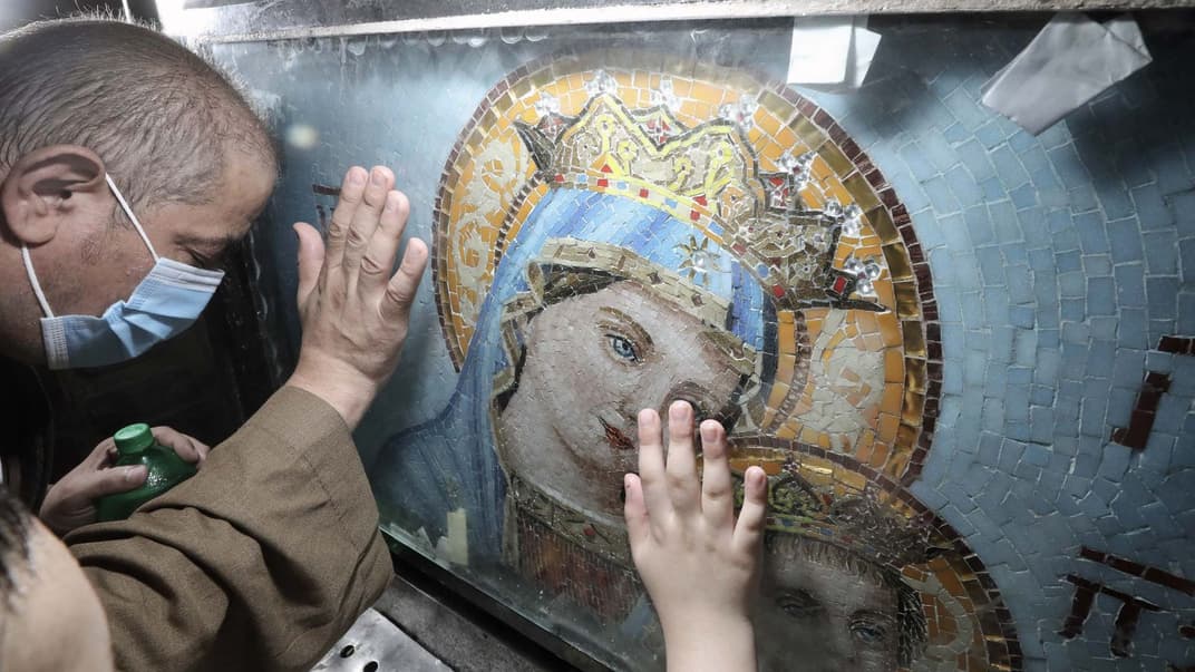 Люди прикасаются к иконе Пресвятой Богородицы после литургии в районе Мостород в Каире, Египет, 3 августа 2020 года