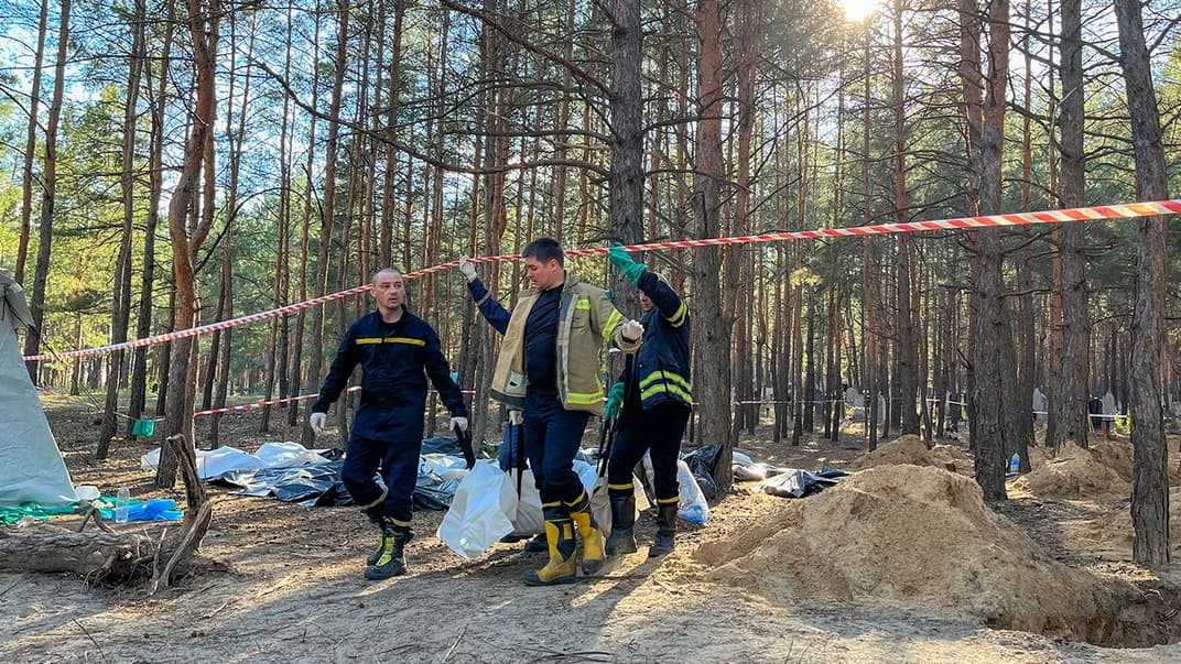 Судово-медичні експерти забирають тіла з масових поховань в Ізюмі
