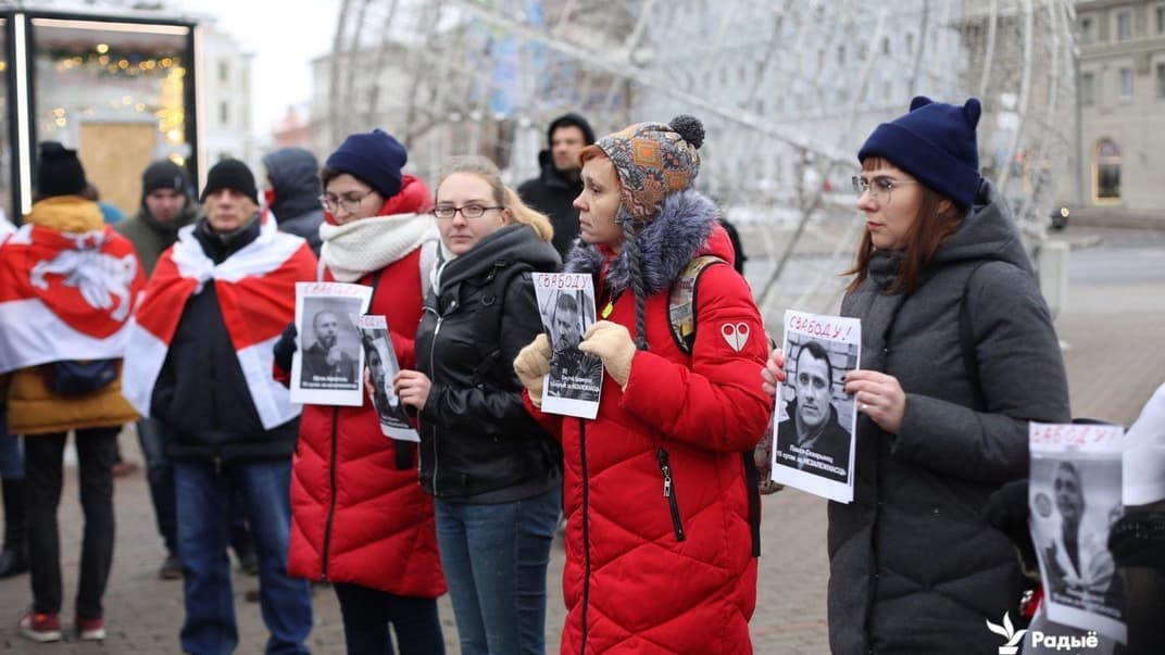 Протестующие держат портреты заключенных оппозиционеров