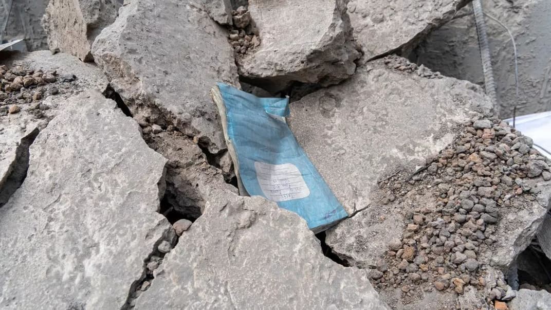 Учнівський зошит на руїнах зруйнованої під час вибуху ракети школи №17 у Харкові, 2 червня 2022 року