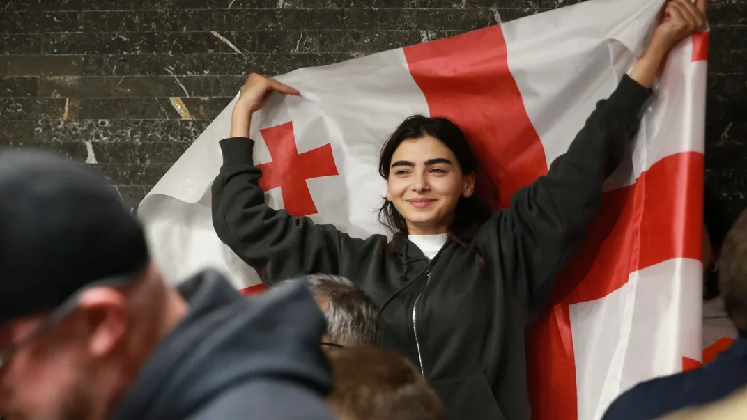 Прихильниця опозиційної партії тримає прапор Грузії після закриття виборчих дільниць