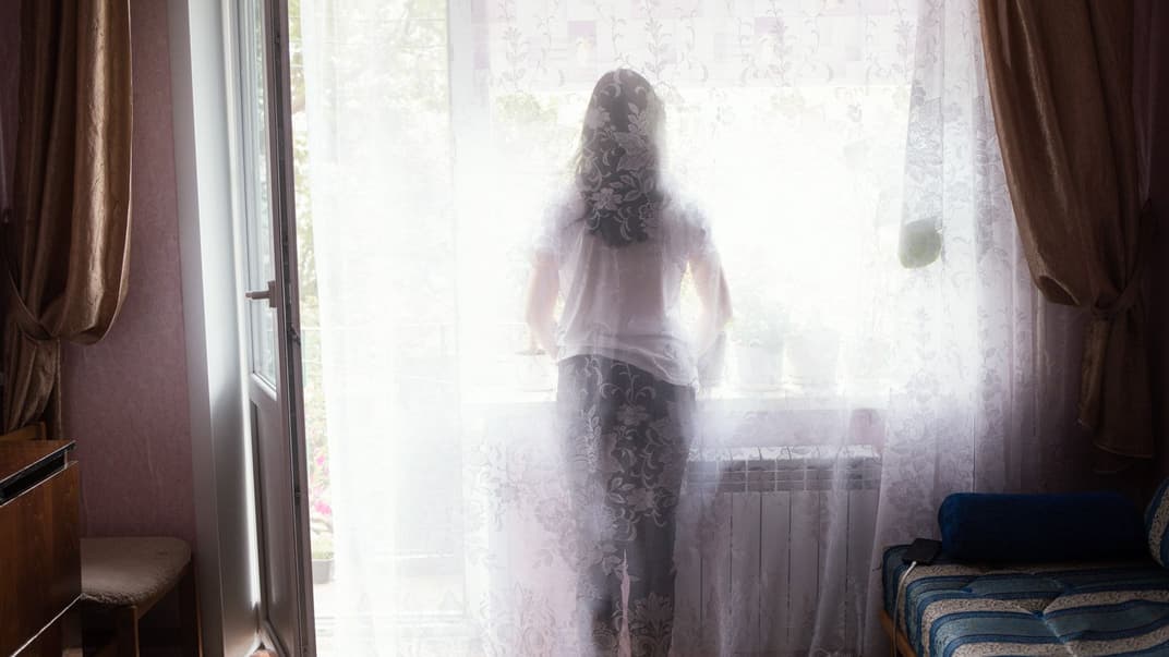 Аліна, донька зниклого безвісти агронома Сергія Резніка, дивиться у вікно будинку в місті Покровськ Донецької області