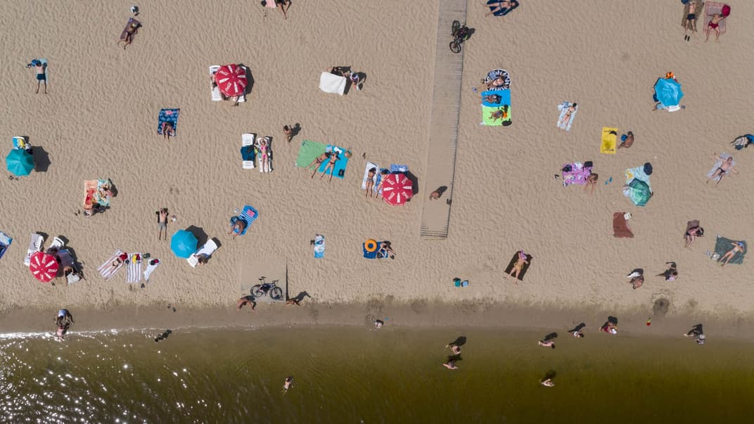 Люди загорают и купаются в Днепре на городском пляже Киева, 12 июня 2020 года