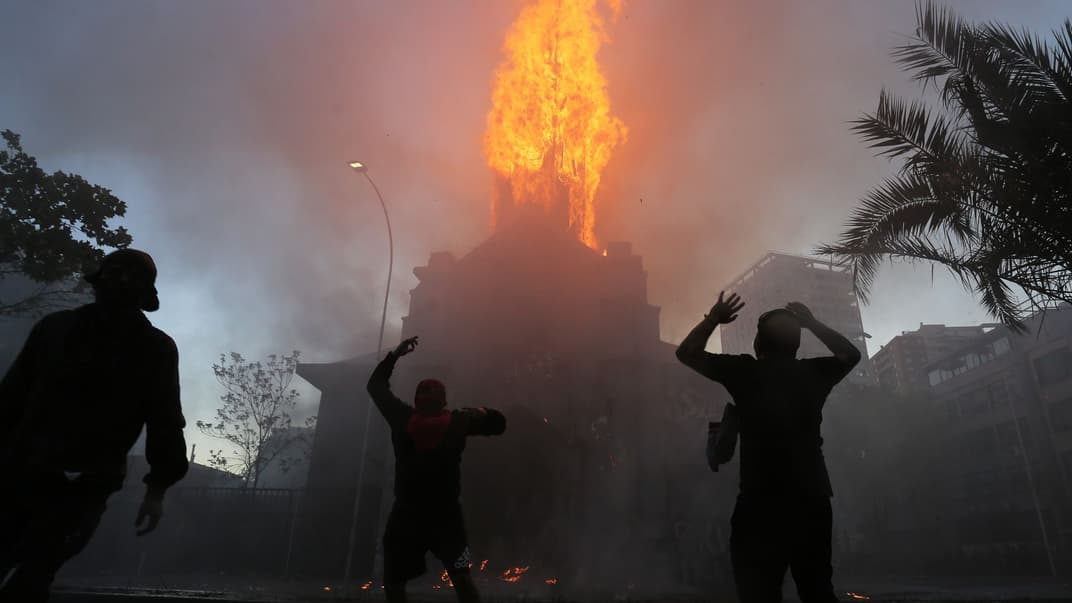 Пожежники працюють над ліквідацією пожежі після акції протесту в Сантьяго, Чилі, 18 жовтня 2020 року