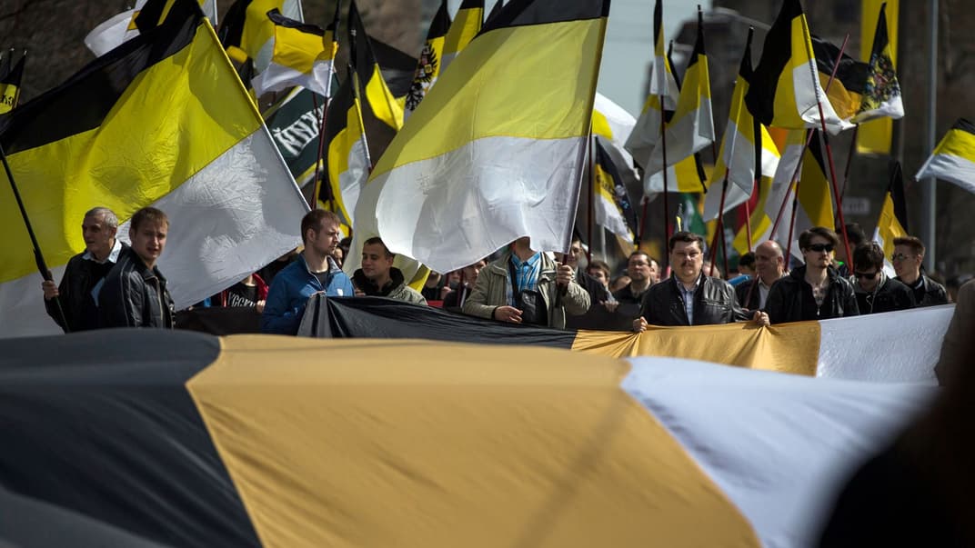 Група людей із чорно-жовто-білими прапорами під час маршу з нагоди Першого травня в Москві, 2013 рік