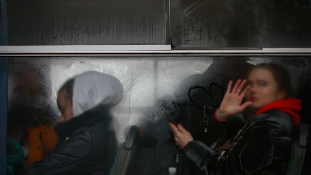 Жінка їде автобусом з іншими українськими біженцями, дивиться у вікно біля прикордонного переходу в Корчеві, Польща, 5 березня 2022 року