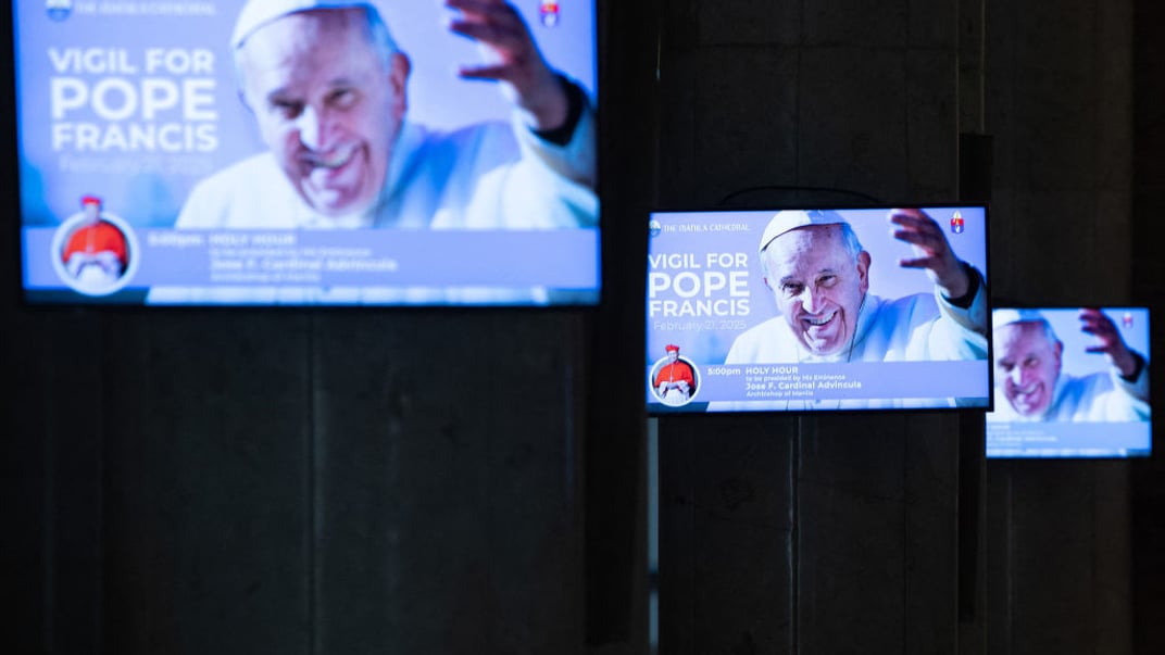 Ілюстративне фото. Фото Папи Римського Франциска показують на моніторах у Манілі після оголошення про молитовні читання за його здоров'я, 20 лютого 2025 року