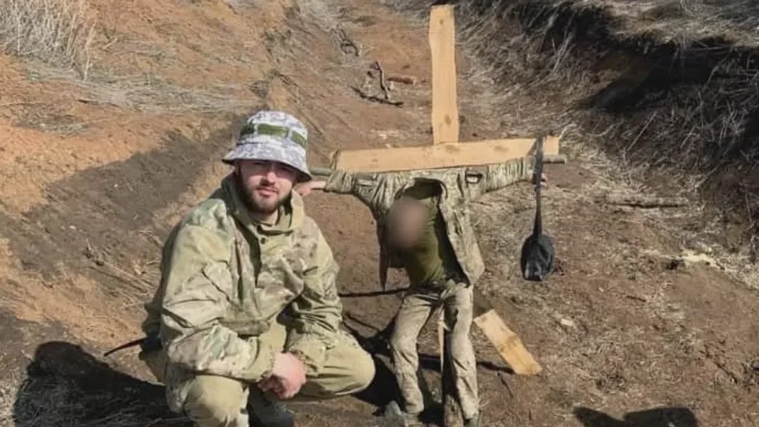 Підлеглий Олега Побережнюка, Владислав Пастух, фотографується на тлі прив'язаного до хреста військовослужбовця