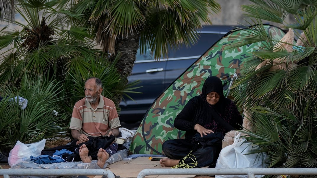 Переміщена сім'я, яка тікає від ізраїльських авіаударів на півдні, сидить на тротуарі на набережній Бейрута, Ліван, 14 жовтня 2024 року