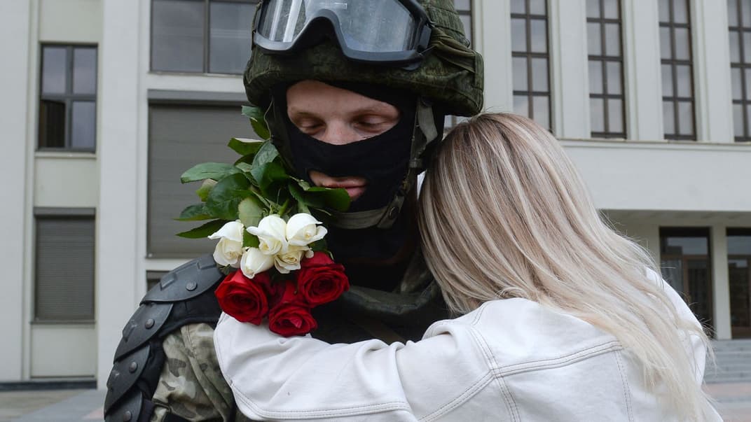 Женщина обнимает спецназовца под МВД Беларуси во время митинга в поддержку белорусской оппозиции, против жестокости милиции и результатов белорусских президентских выборов, Минск, Беларусь, 14 августа 2020 года