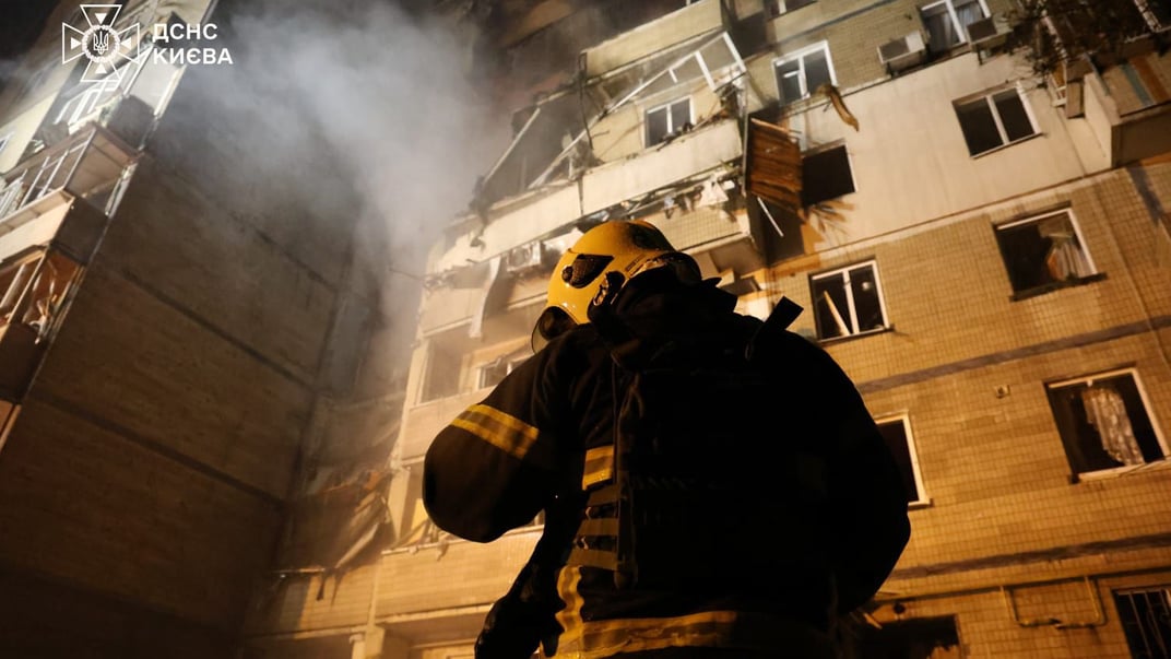Рятувальник на тлі пошкодженої багатоповерхівки у Києві, 7 веречня 2025 року