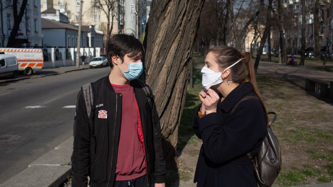 Мужчина и женщина гуляют по киевской улице во время карантина