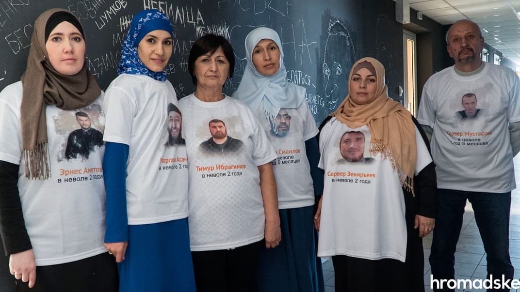 Слева направо родственники заключенных крымских татар: Элеонора Аметова, Айше Асанова, Нияра Ибрагимова, Лиля Смаилова, Зарема Зекирьяева и Рустем Мустафаев у стены в коридоре hromadske, на которой высечены имена политзаключенных, удерживаемых в России и в оккупированном Россией Крыму, Киев, 13 октября 2019 года