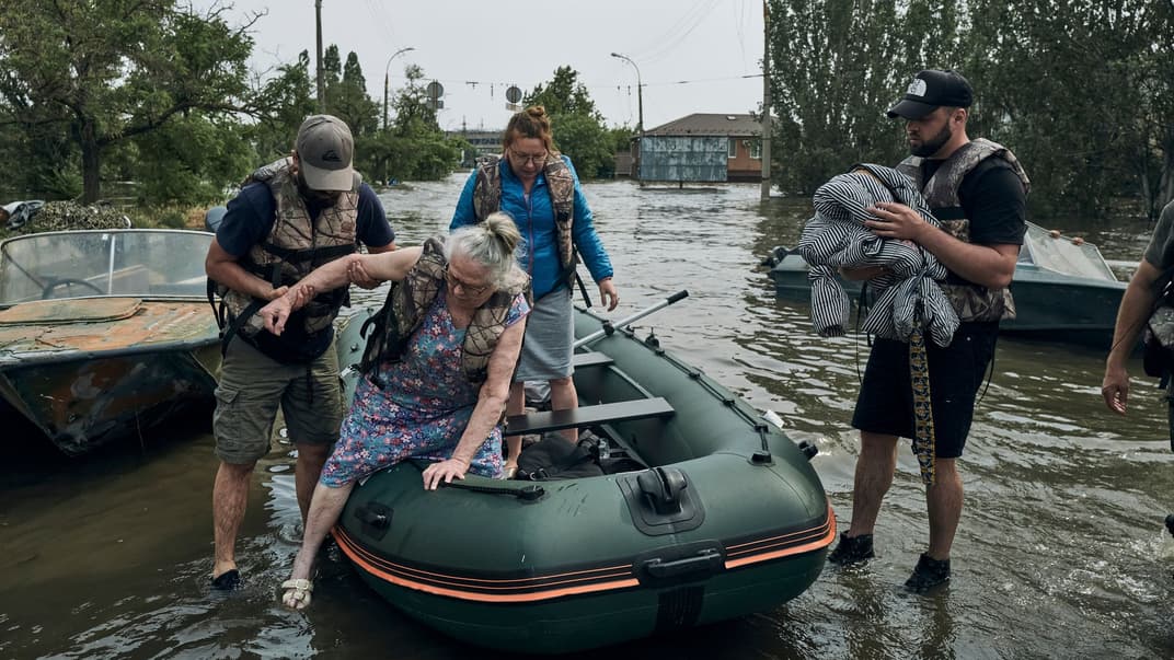 Спасатели эвакуировали жителей на резиновой лодке из затопленного района в Херсоне, 7 июня 2023 года
