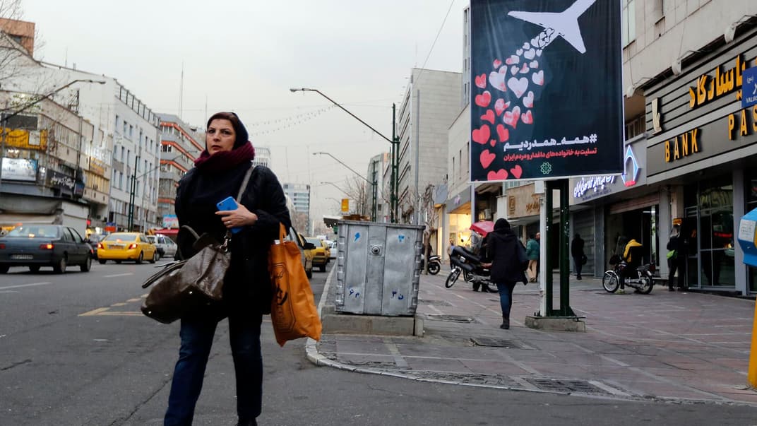 Іранська жінка проходить повз плакат із зображенням літака і написом перською мовою «нам усім болить, ми співчуваємо» — символічний знак вшанування жертв авіакатастрофи українського пасажирського літака компанії МАУ, збитого іранською ракетою після зльоту з аеропорту Тегерану, Іран, 13 січня 2020 року