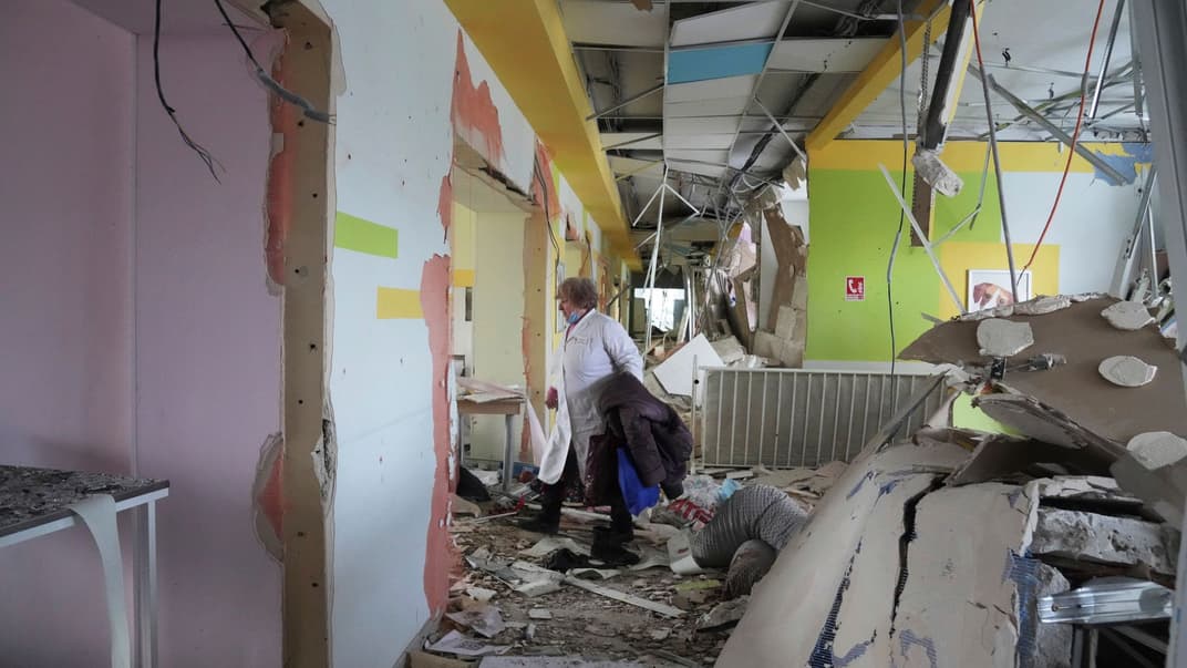 Сотрудница больницы в Мариуполе идет по разбомбленному коридорому, 9 марта 2022 года