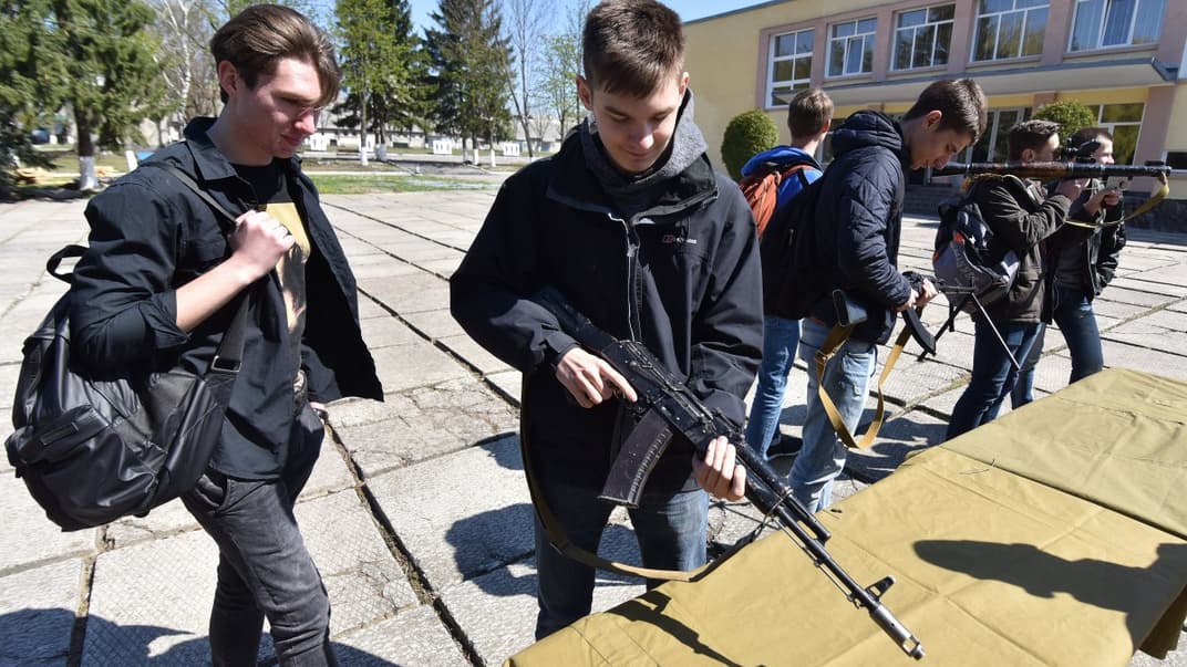 Школьники рассматривают автомат во время мероприятия в соответствии с программой предмета «Защита Украины» (тогда – «Защита Отечества»). Фото: Паламарчук Павел / УНИАН