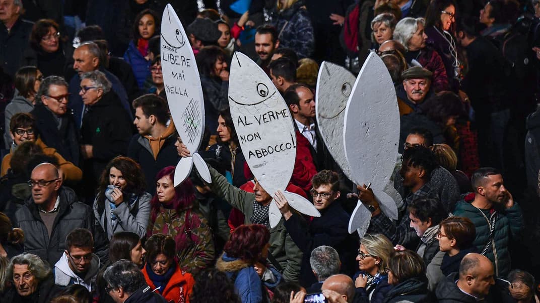 Тысячи сторонников антисальвинивского левого движения «сардин» с символами протеста — картонными сардинами — на площади в городе Генуя, Италия, 28 ноября 2019 года