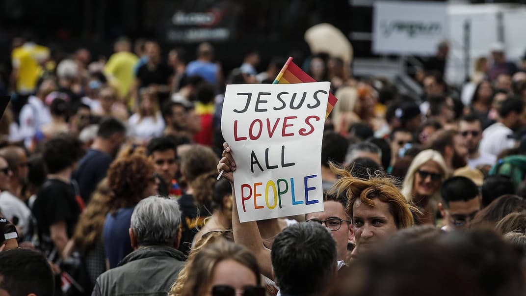 Участники Рим-Прайда держат плакат с лозунгом «Иисус любит всех людей», 9 июня 2018 года