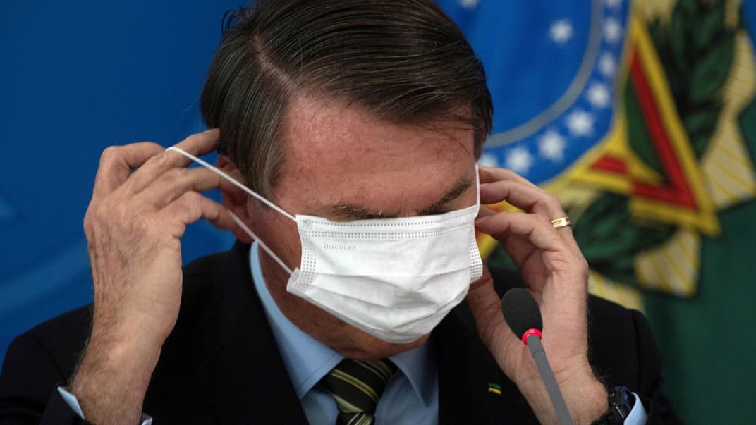 Президент Бразилії Жаїр Болсонару надягає захисну маску для обличчя під час прес-конференції в Бразилії, Бразилія, 18 березня 2020 року