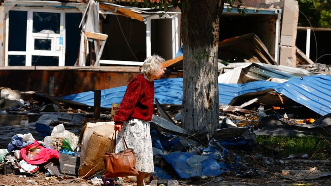 Женщина идет по улице Мариуполя, 27 мая 2022 года