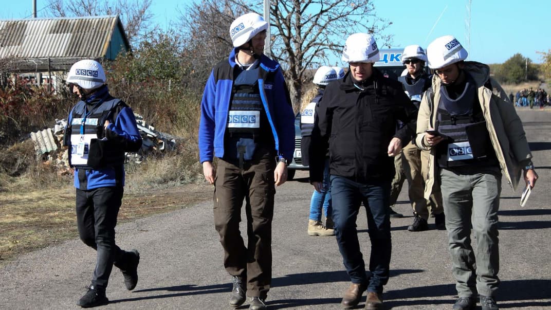 Заместитель главы Специальной мониторинговой миссии ОБСЕ Марк Этерингтон (второй справа) и другие члены ОБСЕ идут по улице рядом с линией фронта в Петровском, Украина, 9 октября 2019 года.