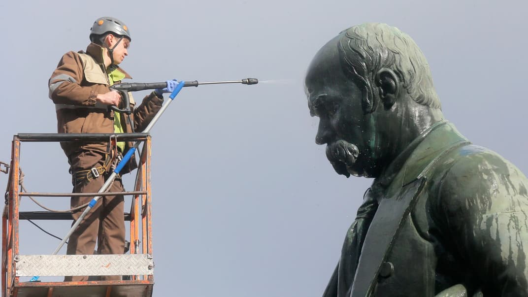 Рабочий моет памятник украинскому поэту Тарасу Шевченко в Киеве, 7 марта 2017 года