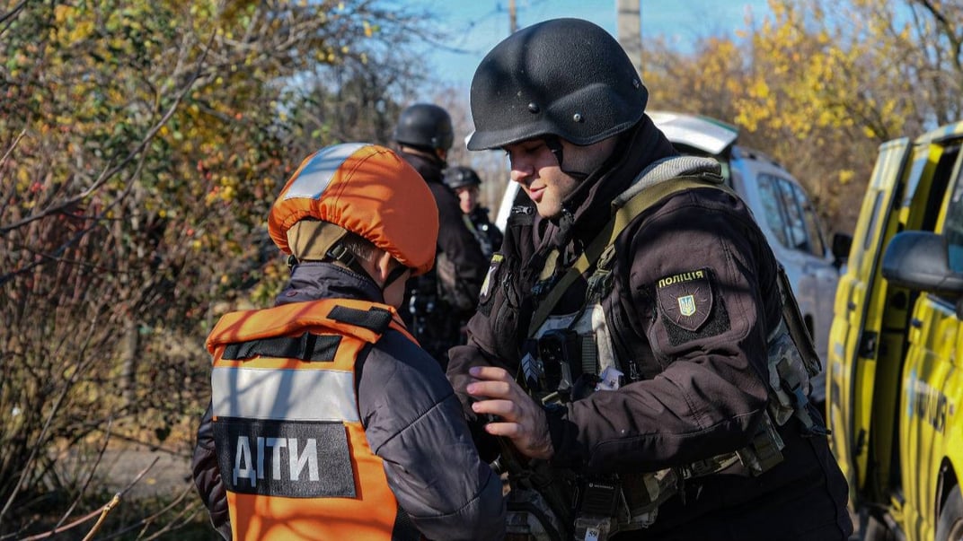 Ілюстративне фото. Поліціянт допомагає дитині на Донеччині евакуюватися у більш безпечний регіон